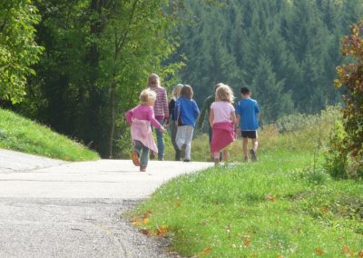 A family of seven walks into the distance on a paved path